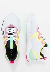 Weiße Sportschuhe mit Mesh-Obermaterial, versehen mit Akzenten in Pink, Gelb und Mintgrün. Schwarze Einfassung und Gummisohlen mit strukturiertem Grip.