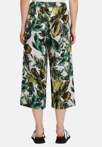 Květinové zkrácené kalhoty v zelené, žluté a bílé barvě. Vyrobené z lehkého materiálu, s širokými nohavicemi a elastickým pasem.
