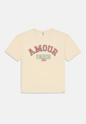 Κοντομάνικο T-shirt εκρού με τη λέξη "AMOUR" με γράμματα από ροζ λουλούδια, το "PARIS" σε πράσινο και το "1995" σε μικρό κόκκινο κείμενο από κάτω.