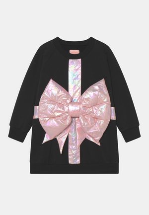 Sudadera negra con un gran lazo y detalle de cinta en color rosa iridiscente en la parte frontal. Textura suave con mangas largas y diseño de cuello redondo.