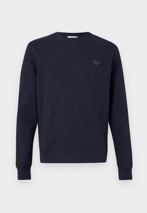 Laivastonsininen pitkähihaisen crewneck-hupparin, jossa on resorit hihansuissa ja pieni sydämen kuvio vasemmassa rinnassa.