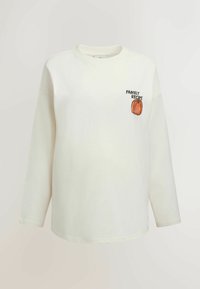 White long-sleeve shirt with round neckline, featuring a small orange pumpkin and "Family Recipe" text on the chest.