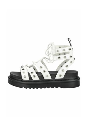 Sandale gladiateur en cuir blanc avec clous argentés, laçage à l’avant, semelle épaisse noire et languette au talon.