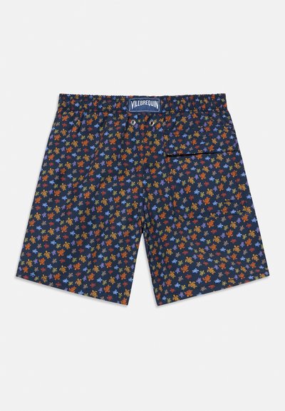 Granatowe kąpielówki w kwiatowy wzór w kolorach pomarańczowym, żółtym i niebieskim. Elastyczny pas ze sznurkiem oraz detal w postaci bocznej kieszeni.