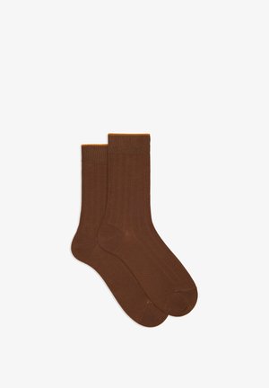 Calze di cotone marroni con una texture a coste e un accento arancione nella parte superiore, abbinate in un design a lunghezza standard.