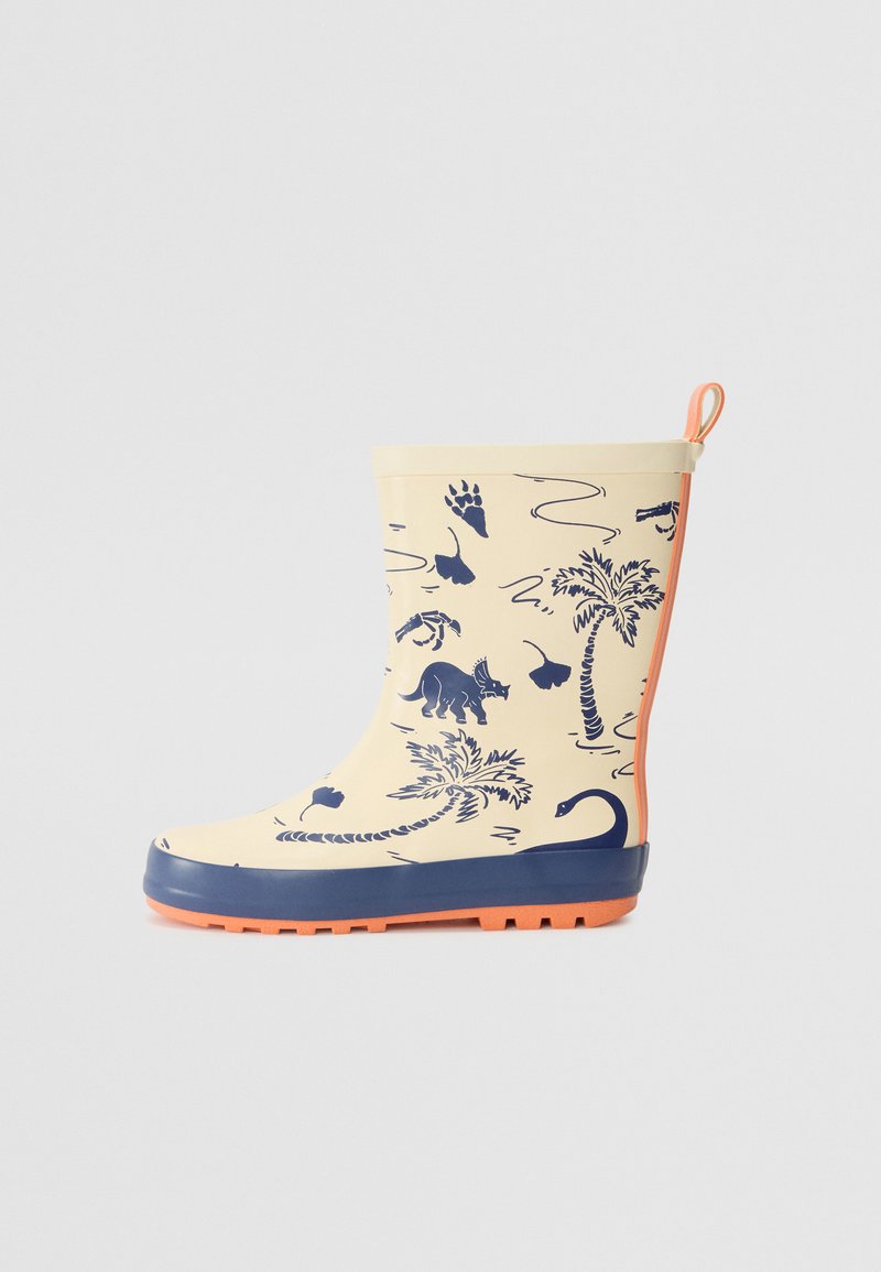 Botte de pluie en caoutchouc jaune avec une semelle bleue, ornée d'imprimés de dinosaures navy, de palmiers et d'animaux. Comprend une languette orange pour un enfilage facile.