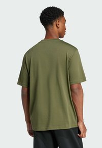 Olivovozelené tričko s krátkym rukávom, vyrobené z mäkkej tkaniny, s okrúhlym výstrihom a voľným strihom, zobrazené zozadu.