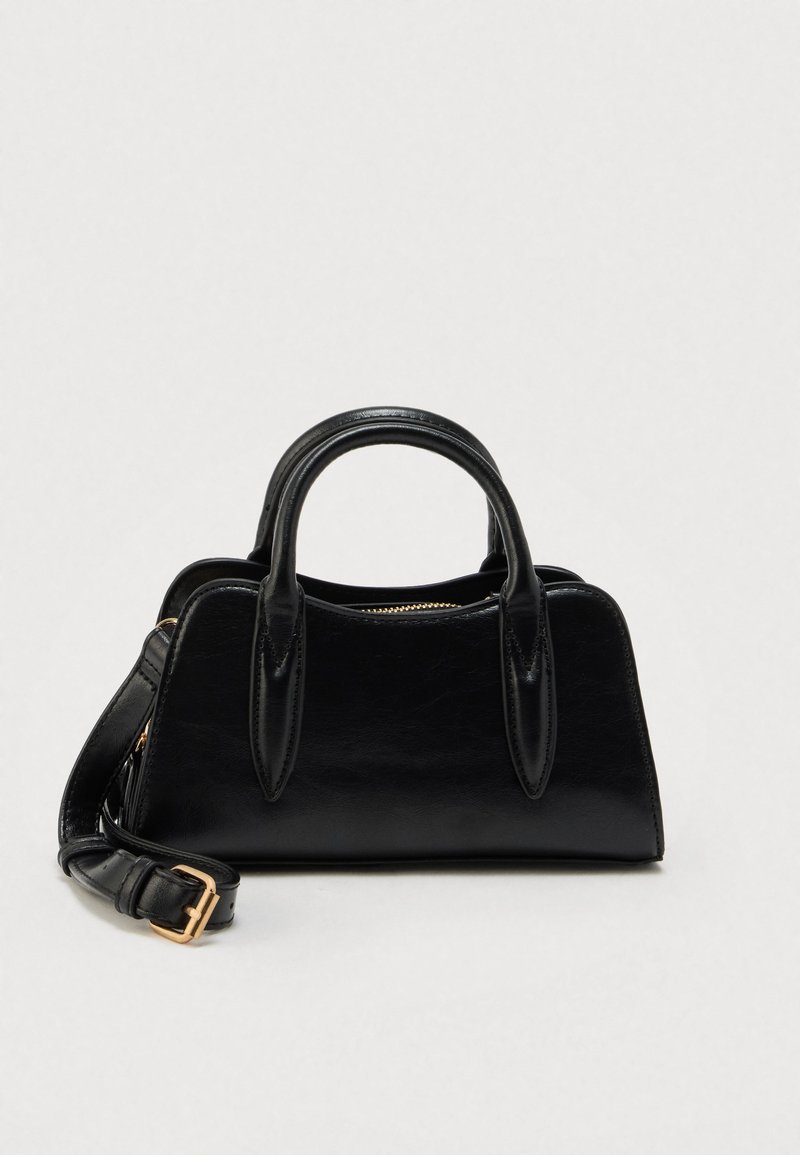 Sac à main en cuir noir avec double poignée et bandoulière détachable à boucle dorée, présenté sur un fond blanc uni.