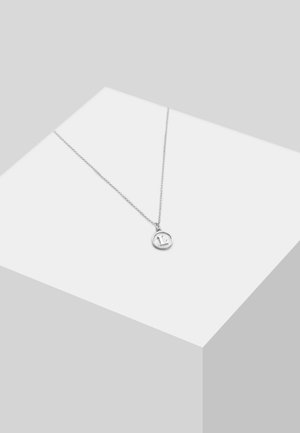 Silberne Halskette mit einem runden Anhänger an einer dünnen Kette, die eine strukturierte Oberfläche und subtile gravierte Details aufweist.