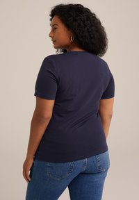 Camiseta de manga corta azul marino, hecha de una mezcla de algodón, diseño ajustado con cuello redondo, que muestra una textura suave y sin adornos.