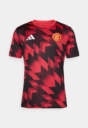 Sarkans un melns Manchester United krekls ar ģeometrisku rakstu, īsām piedurknēm, apaļu kaklu un izšūtu kluba logo uz krūtīm.