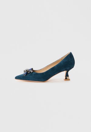 Pump in camoscio teal con tacco kitten a punta e decorazione in argento e blu con gemme sopra.