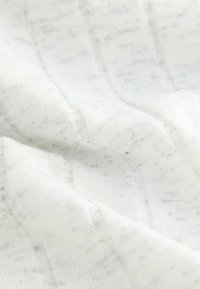 Weißer Stoff mit einem strukturierten Muster aus feinen vertikalen Linien und Sprenkeln dunkler Fasern, das eine weiche, leicht flauschige Oberfläche zeigt.