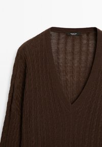 Pull en maille torsadée marron foncé avec col en V et manches longues, étiqueté Massimo Dutti.