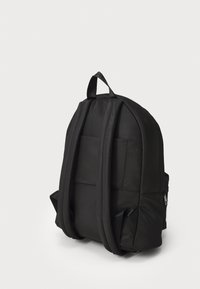 Black nylon backpack with padded back, two adjustable straps, and a top handle. Features minimalist design and rectangular shape with side pockets.