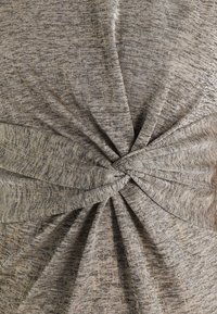 Tissu en tricot gris et texturé avec un design à front torsadé, présentant des éclats subtils et des fronces qui créent un effet drapé.