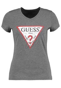 Grå kortärmad t-shirt med en triangelformad röd och vit grafik med "GUESS" och ett frågetecken, dekorerad med strass.