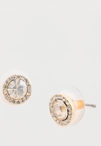 Aranyszínű fülbevalók, amelyek középpontjában egy nagy, tiszta kristály található, amelyet kisebb tiszta kövek gyűrűje vesz körül, sima hátlappal.