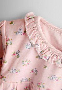 Rochie din bumbac roz cu un guler volănaș, decorată cu un model floral și ilustrații cu șoareci mici. Textură moale, țesătură ușoară.