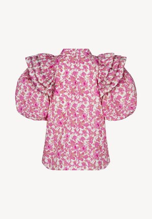 Roze gebloemde blouse met grote geplooide mouwen en ruches langs de schoudernaden op een witte achtergrond.