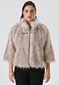 Faux-Fur-Wickeljacke in hellem Beige mit einer flauschigen Textur, ausgestattet mit einem breiten Kragen und kurzen Ärmeln, die mit einem metallischen Verschluss gesichert ist.