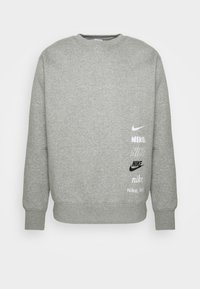 Šedá bavlněná mikina s kulatým výstřihem, na přední straně s mnoha logy Nike v černé a bílé barvě. Pohodlný střih a žebrované manžety.