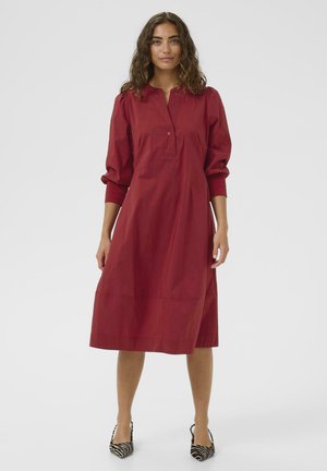 Rotes Kleid aus leichtem Stoff, mit einem kragenlosen Ausschnitt, Knopfleiste und drei Viertel-Ärmeln. A-Linie Silhouette, knielang.