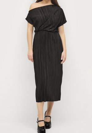 Black pleated midi dress with an off-shoulder design, featuring a gathered waist and flowing silhouette. Shiny material with smooth texture.
