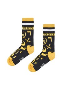 Chaussettes montantes noires et jaunes avec des rayures blanches, des symboles graphiques, le texte « Von Dutch » et des sections talon et orteil jaunes contrastantes.