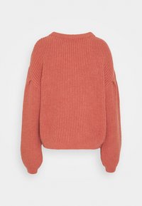 Korallenfarbener, übergroßer Strickpullover mit Rippstruktur, Rundhalsausschnitt und Ballonärmeln. Die Rückansicht zeigt eine verkürzte Silhouette.