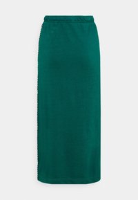 Turkoosi midihame, jossa on joustava vyötärönauha, valmistettu pehmeästä kankaasta. Siinä on sileä pinta ja sivussa kontrastivärinen koriste.