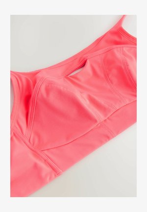 Soutien-gorge de sport rose avec une texture lisse, des coutures structurées et un détail découpé à l'avant. Bretelles réglables pour un ajustement optimal.