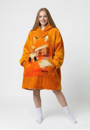 Noor naine kannab üle mõõdu oranzhi kapuutsiga fliisi, mille esitaskul on suur rebane, kes hoiab auravat tassi.