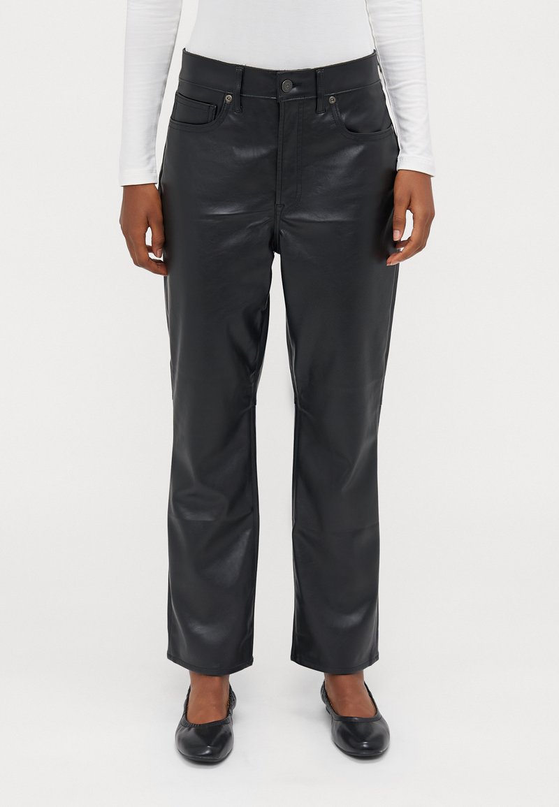 Calças de imitação de pele pretas com um design de perna reta, bolsos frontais e botões de metal prateado. A superfície tem uma textura lisa e brilhante.