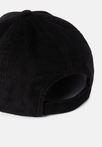 Schwarze Cordmütze mit rundem Schirm, geripptem Muster und offenem Rücken. Verfügt über ein gesticktes Nahtdetail und einen flachen Schirm.