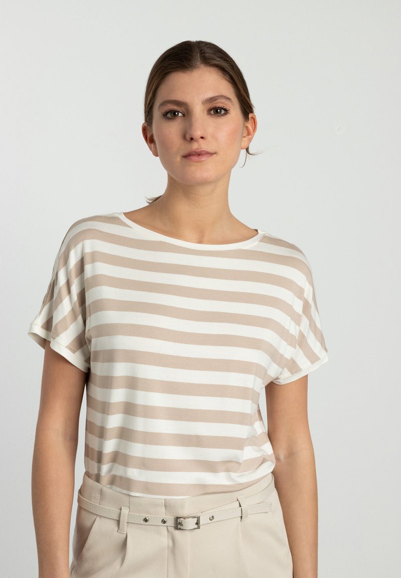 Beige en wit gestreepte t-shirt met een relaxte pasvorm, ronde halslijn en korte mouwen, gecombineerd met lichtgekleurde chino's en een riem.