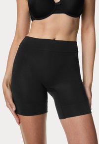 Pantaloni corti neri a vita alta realizzati in tessuto elasticizzato, con una finitura liscia e lunghezza fino a metà coscia, caratterizzati da dettagli di cucitura minimi.