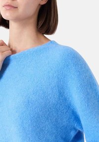 Maglione azzurro chiaro con un morbido lavorato a maglia testurizzato. Collo ampio e vestibilità rilassata, che mette in risalto una silhouette fluida.
