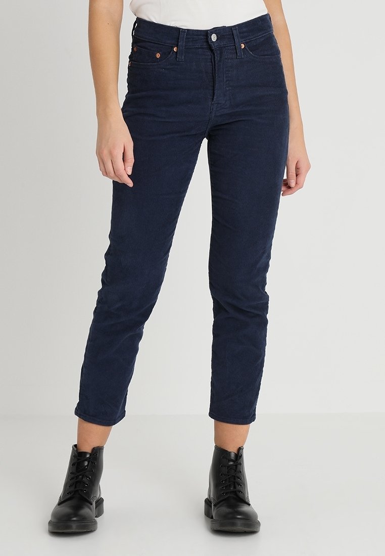 Marina blå kordflöjlsbyxor med hög midja, slim fit, framfickor och subtila sömdetaljer. Bärs med svarta snörade anklarstövlar.