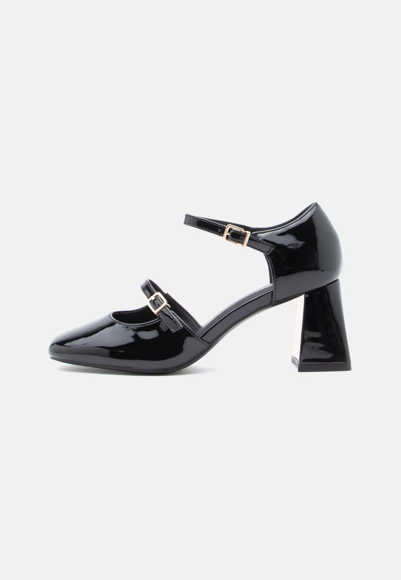 Black patent leather Mary Jane shoe with two adjustable buckled straps and a block heel on a white background.
