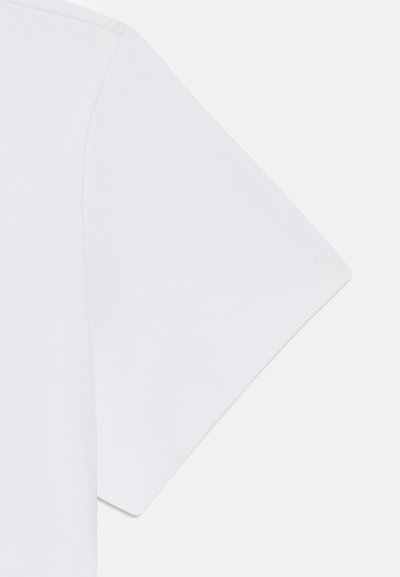 Manga de una camiseta blanca de algodón que muestra una textura suave, costuras limpias y un ligero ángulo ascendente en el hombro. Diseño simple y clásico.