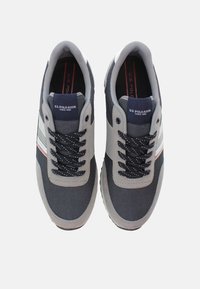Scarpe da ginnastica navy e grigie con materiali in mesh e sintetici. Presentano lacci neri, strisce a contrasto e il logo sulla linguetta.