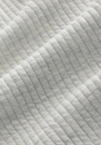 Tejido de punto en gris claro con un patrón texturizado y estriado. Material suave y flexible con líneas horizontales que crean un efecto tridimensional.