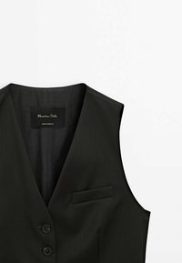 Svart väst med en slät yta, v-halsringning, två knappar, en liten ficka och en etikett inuti. Skräddarsydd design utan ärmar.