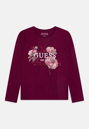 Bordeaux rode lange mouwen t-shirt van biologisch katoen, met een bloemmotief en "GUESS"-logo in zilver en roze op de voorkant.