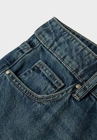 Cintura de jeans de mezclilla con pasadores para cinturón, un bolsillo delantero y un bolsillo pequeño para monedas, mostrando costuras detalladas y remaches de metal.
