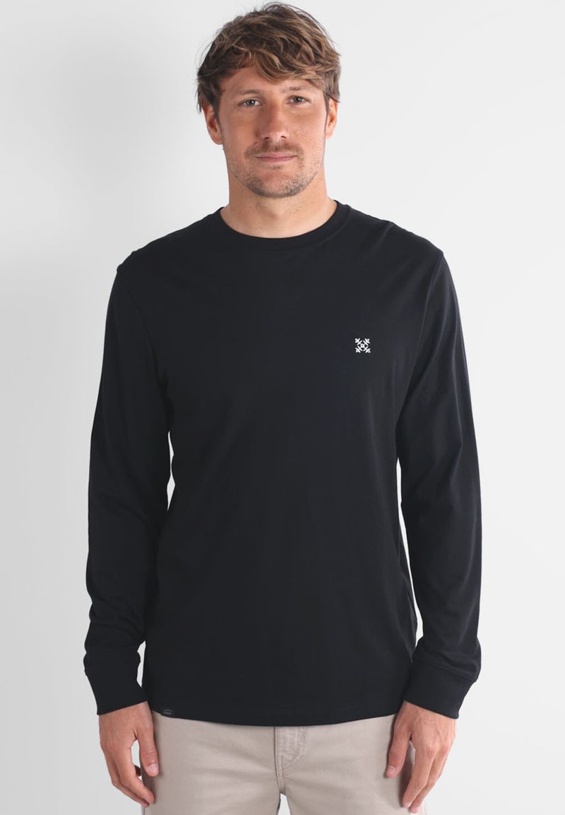 Camiseta de manga larga negra, de material de algodón, con cuello redondo, que presenta un pequeño logo blanco en el pecho y un corte relajado.