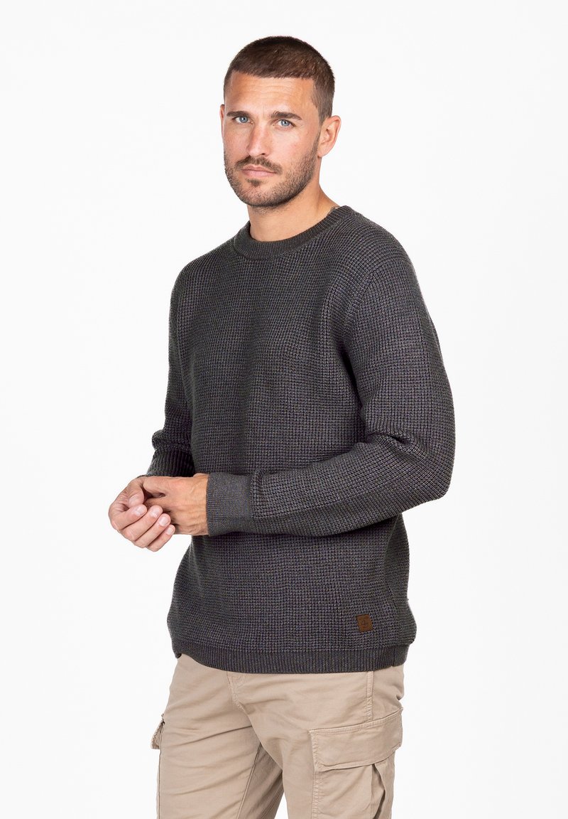 Grau strukturierter Pullover mit rundem Ausschnitt, gerippten Bündchen und Saum. Abgerundet mit einem kleinen Lederlogo-Patch auf der linken unteren Seite.