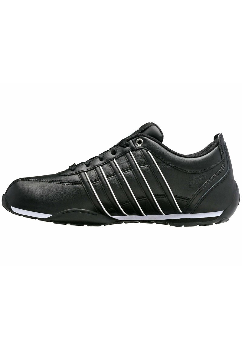 Schwarzer Sportschuh mit einem glatten Lederoberteil, ausgestattet mit fünf weißen Streifen an der Seite, einer gepolsterten Sohle und einem eleganten Design.