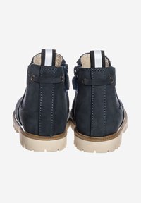 Stivaletti alla caviglia in pelle scamosciata blu scuro con tomaia testurizzata, cuciture a contrasto e suola in gomma chiara. Dotati di linguetta e dettaglio ad anello.